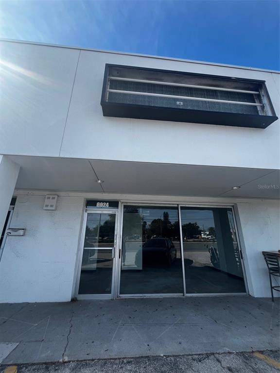 The exterior of a commercial building features a white facade, glass storefront, and signage frame — 6024 SEMINOLE BOULEVARD, SEMINOLE, FL