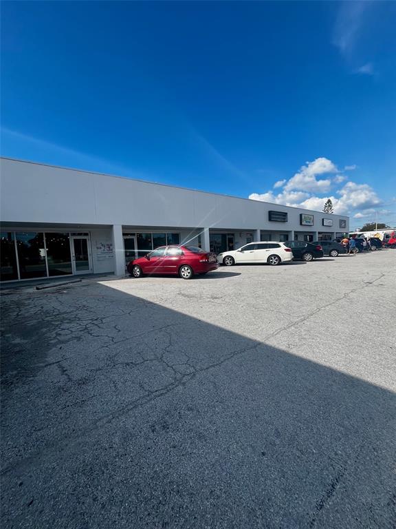 A red sedan is parked in front of a single-story commercial building with multiple storefronts — 6024 SEMINOLE BOULEVARD, SEMINOLE, FL