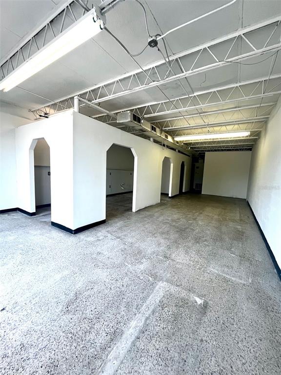 An interior view of a commercial space with white partition walls and exposed ceiling trusses — 6024 SEMINOLE BOULEVARD, SEMINOLE, FL