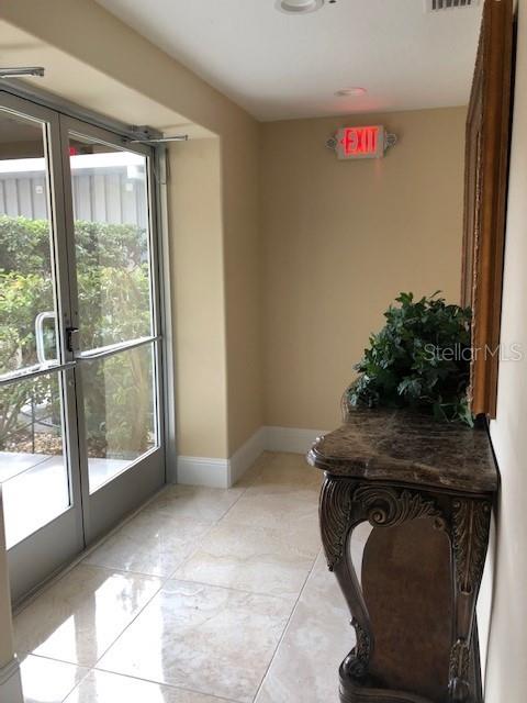 A tiled entryway features a glass double door, a decorative console table, and an exit sign — 350 ANCHOR ROAD ROAD UNIT 1040, CASSELBERRY, FL