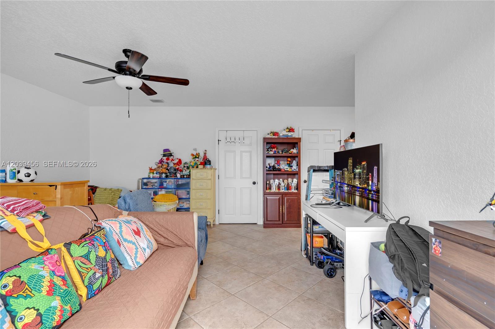 A living room features tile flooring, a ceiling fan, a sofa, and a television stand — FORT LAUDERDALE, FL