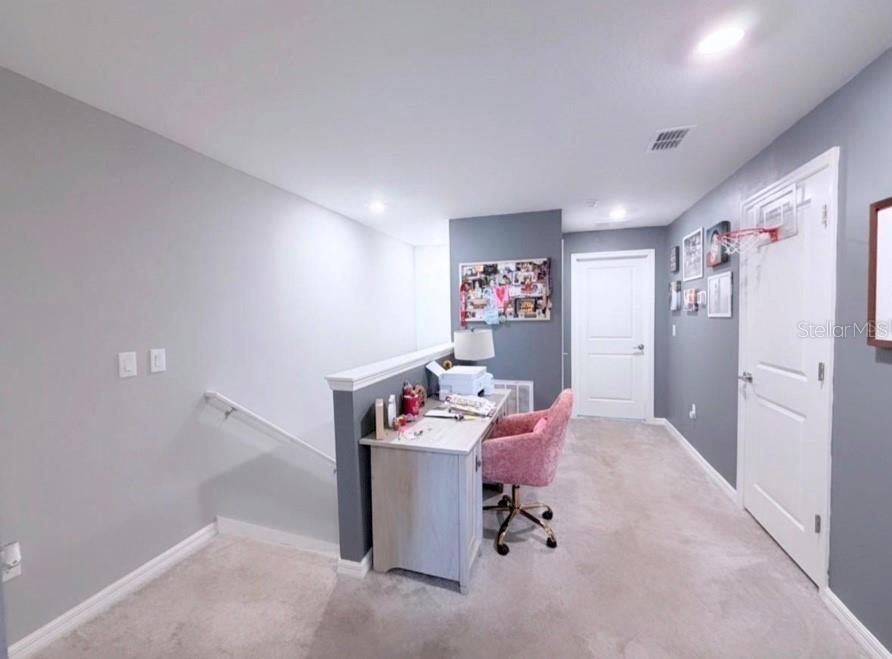 A home office area features a desk, a pink chair, and a staircase landing — 6047 ACARA LANE, LAND O LAKES, FL