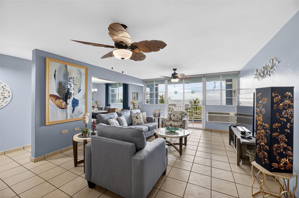A living room with blue walls, tile flooring, two ceiling fans, and a balcony view — Route 102 TORRE MARSELLA CONDOMINIUM UNIT 601, CABO ROJO, PR