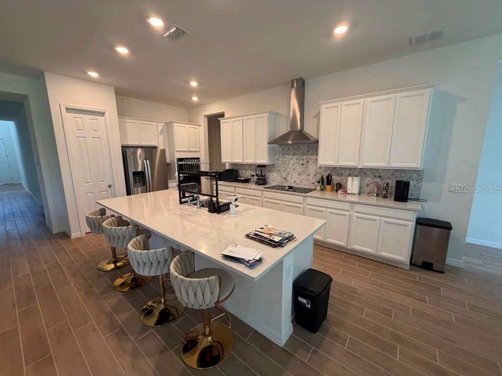 A long hallway with wood-look tile flooring leads toward an open living area — 16091 SILVER BROOK WAY, WINTER GARDEN, FL