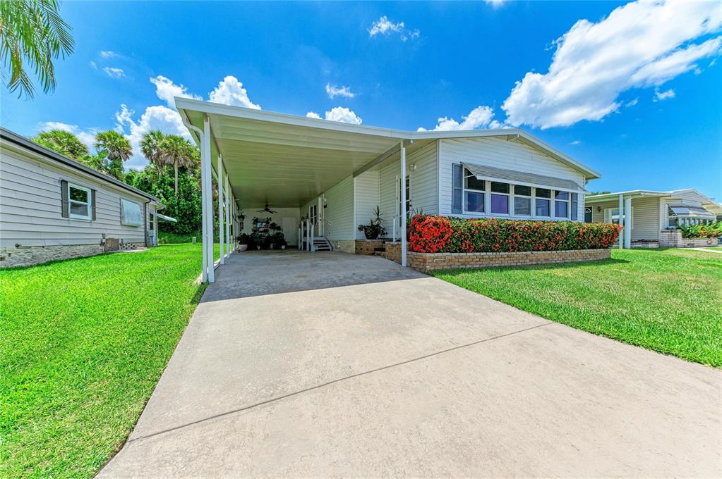 A single-story house with a white exterior, a concrete driveway, and a covered carport — 4543 12TH STREET COURT E, ELLENTON, FL