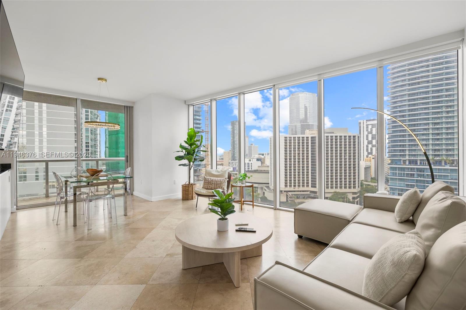 A modern living and dining area features floor-to-ceiling windows with expansive city views — 485 Brickell Ave # 1804, Miami FL 33131, MIAMI, FL