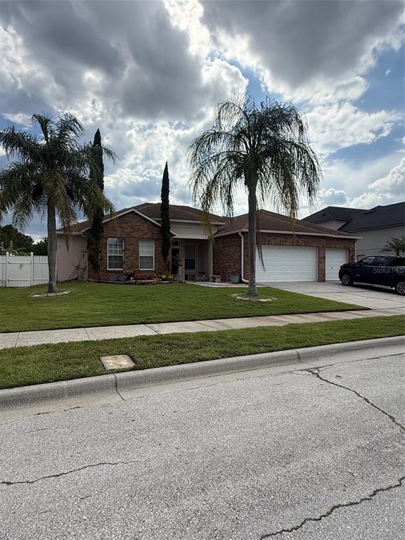 A single-story brick house with a three-car garage and two palm trees in the front yard — 5026 QUALITY TRAIL, ORLANDO, FL