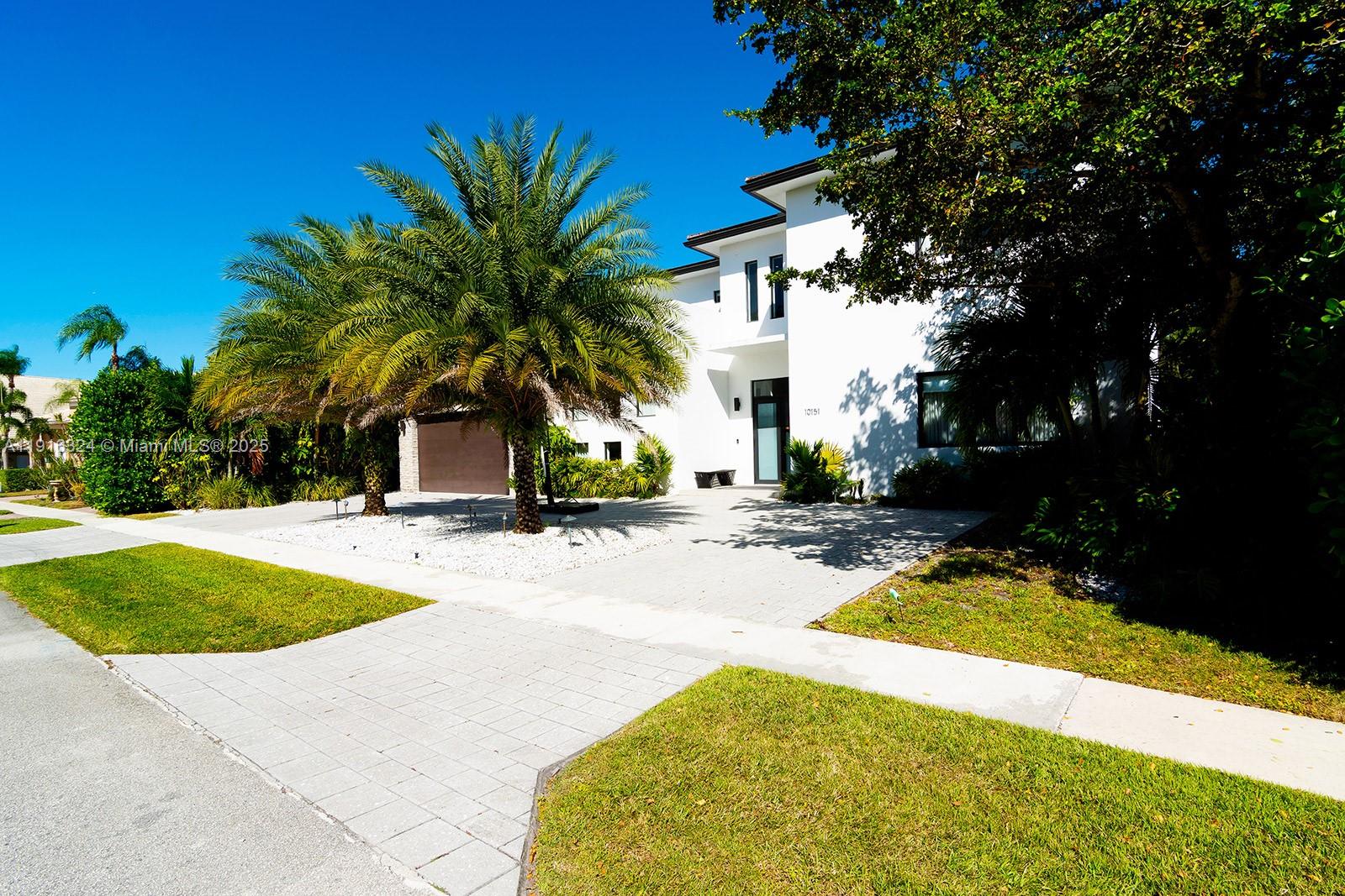A modern white two-story house features a palm tree in the front yard — 10151 SW 3rd St, Plantation FL 33324, PLANTATION, FL