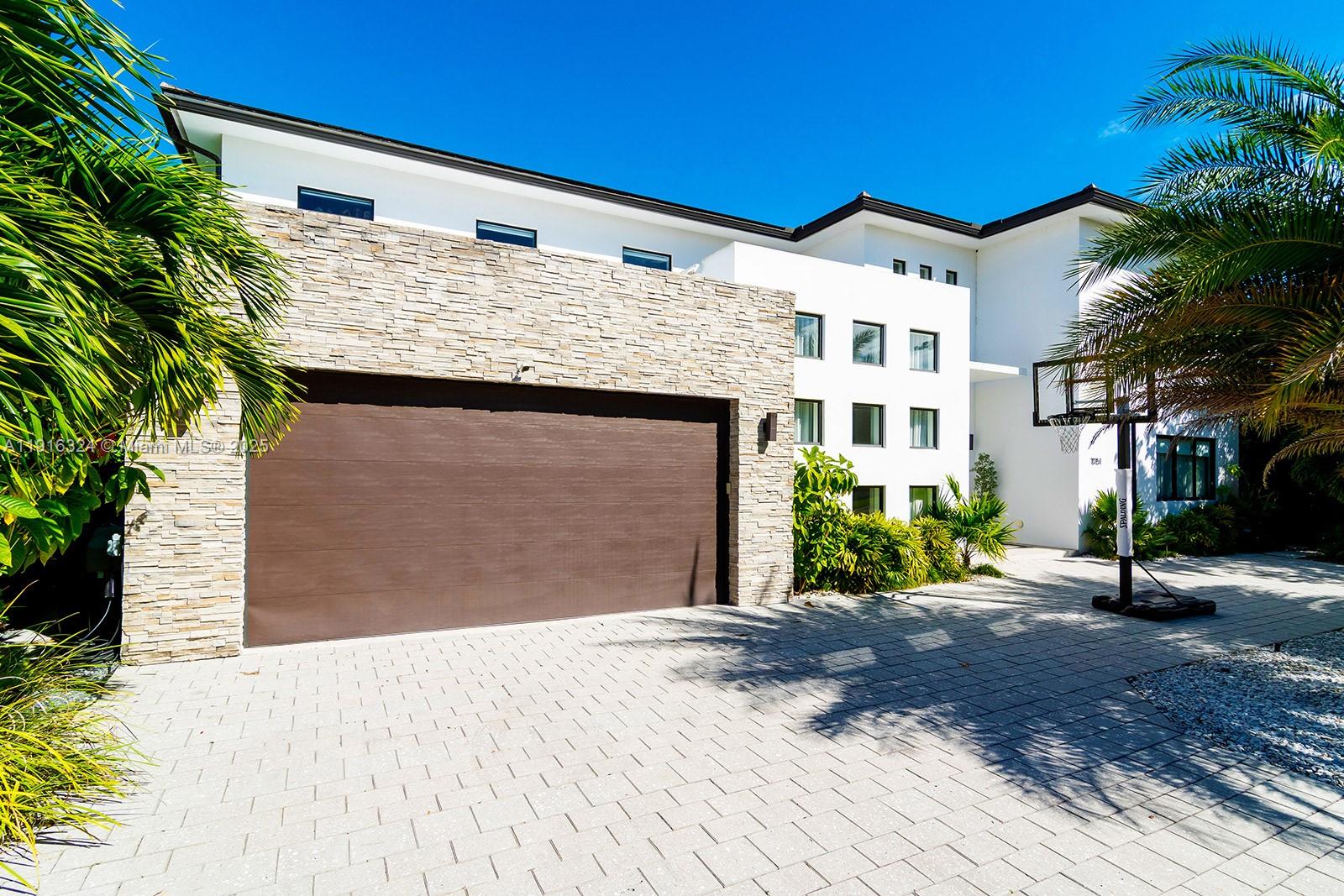 A modern two-story house features a stone-accented garage and a paved driveway with a basketball hoop — 10151 SW 3rd St, Plantation FL 33324, PLANTATION, FL