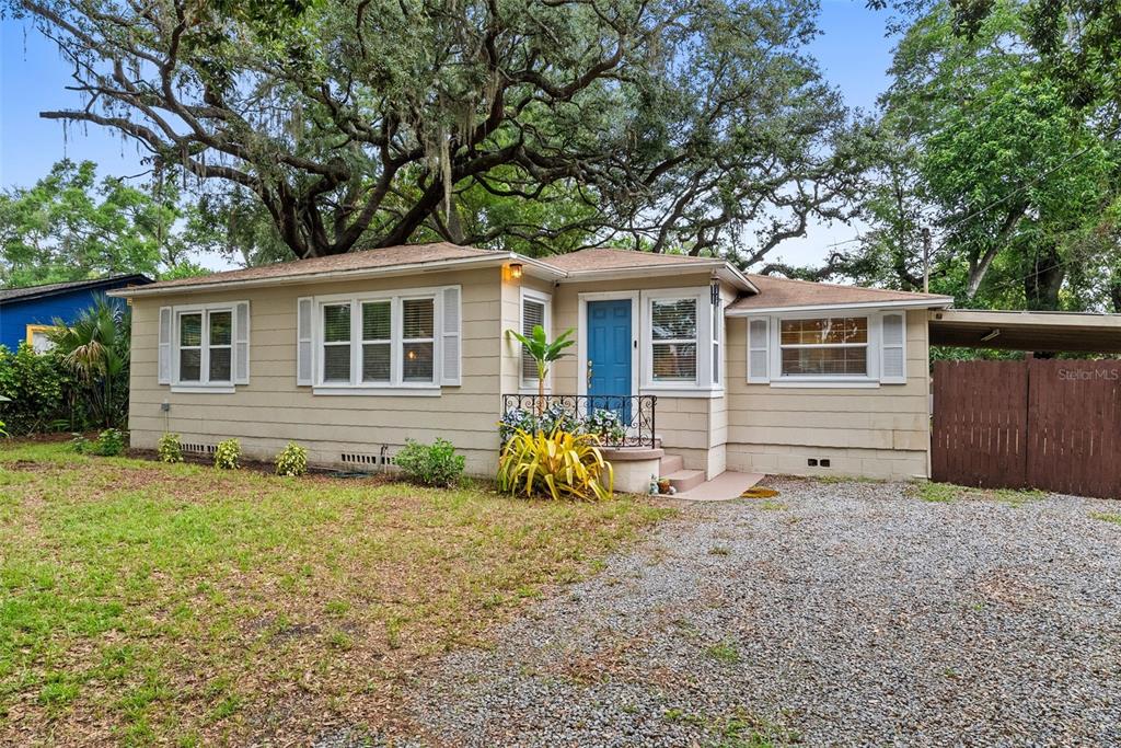 A living room features a yellow sectional sofa, hardwood floors, and an arched entryway — 2016 E POWHATAN AVENUE, TAMPA, FL