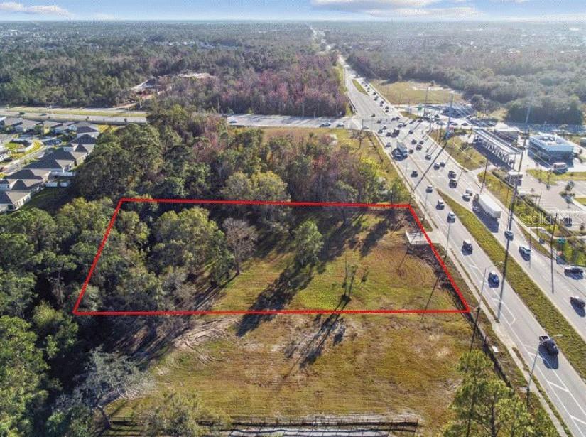An aerial view shows a rectangular vacant lot outlined in red next to a highway — 6020 US HIGHWAY 17 92 N, DAVENPORT, FL