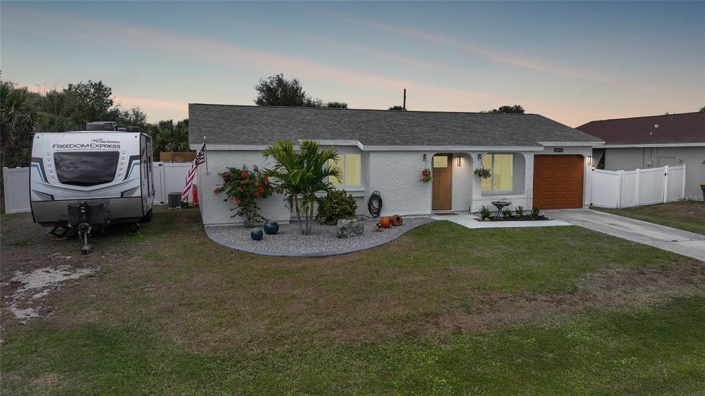 A kitchen features white cabinets, stainless steel appliances, granite countertops, and a double-basin sink — 18970 MCGRATH CIRCLE, PORT CHARLOTTE, FL