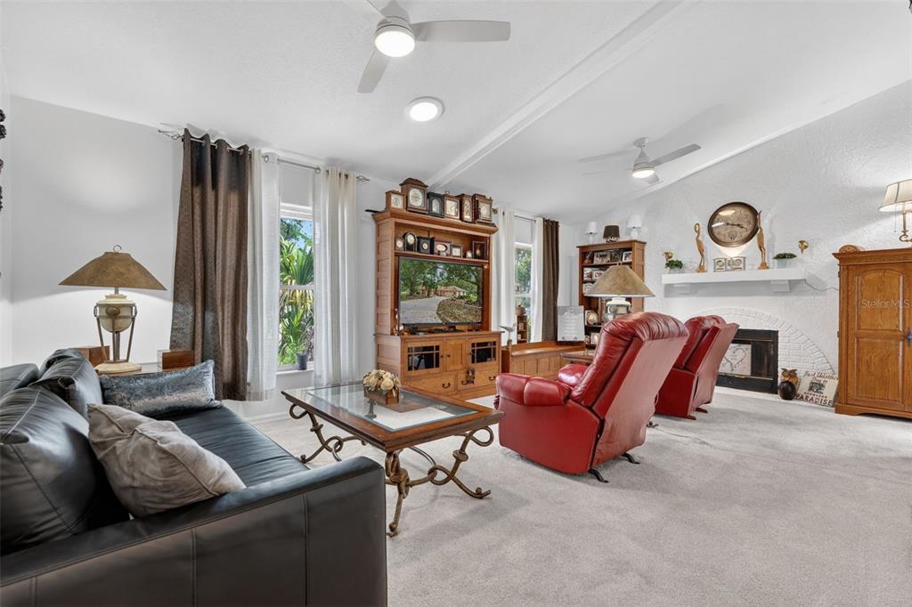 A living room features a black leather sofa, red recliners, and a wooden entertainment center — 507 E GILCHRIST COURT, HERNANDO, FL