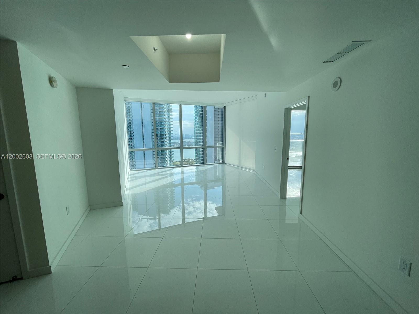 An empty room with white tile floors, a recessed ceiling, and floor-to-ceiling windows — 851 NE 1st Ave # 3103, Miami FL 33132, MIAMI, FL