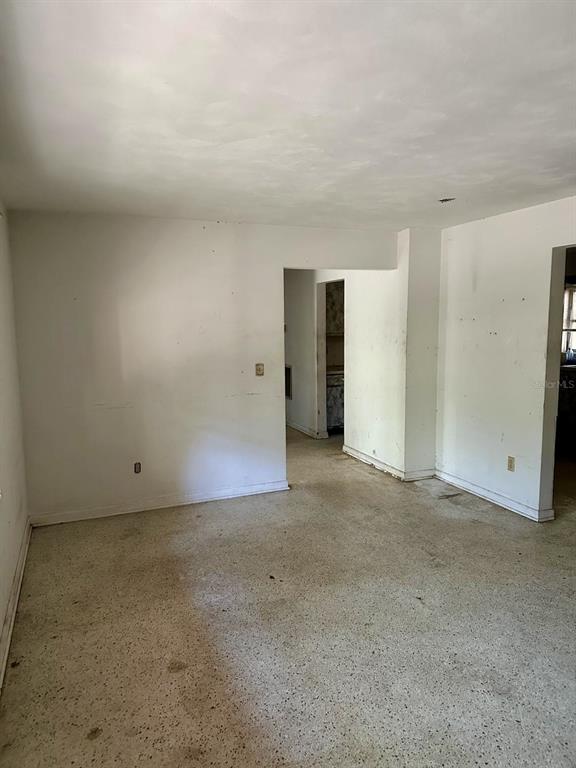 An empty room with white walls, a textured ceiling, and a speckled concrete floor — 1918 MOUNTAIN LAKE CUTOFF ROAD, LAKE WALES, FL