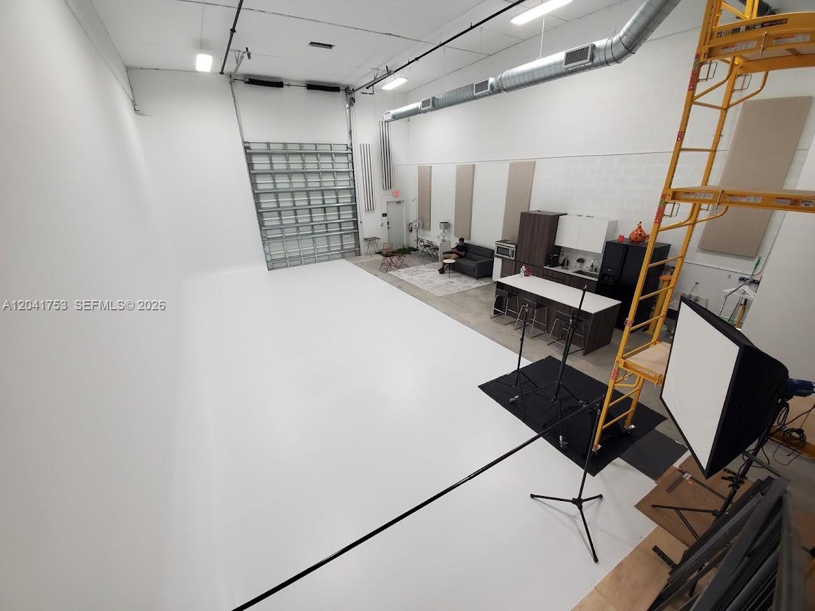 A high-ceilinged studio space features a white cyclorama wall, a kitchenette, and industrial lighting — 2017 NW 135 Avenue, Miami FL 33182, MIAMI, FL