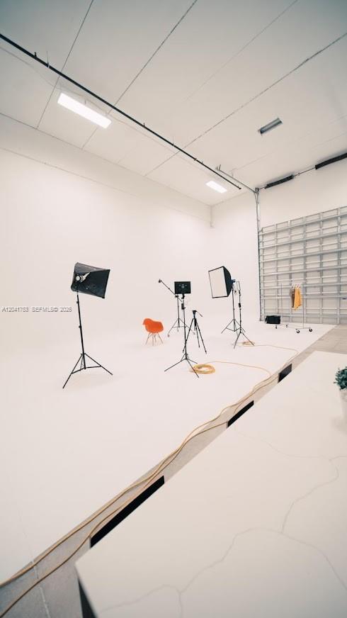 A bright, white-walled photography studio features professional lighting equipment and a small orange chair — 2017 NW 135 Avenue, Miami FL 33182, MIAMI, FL