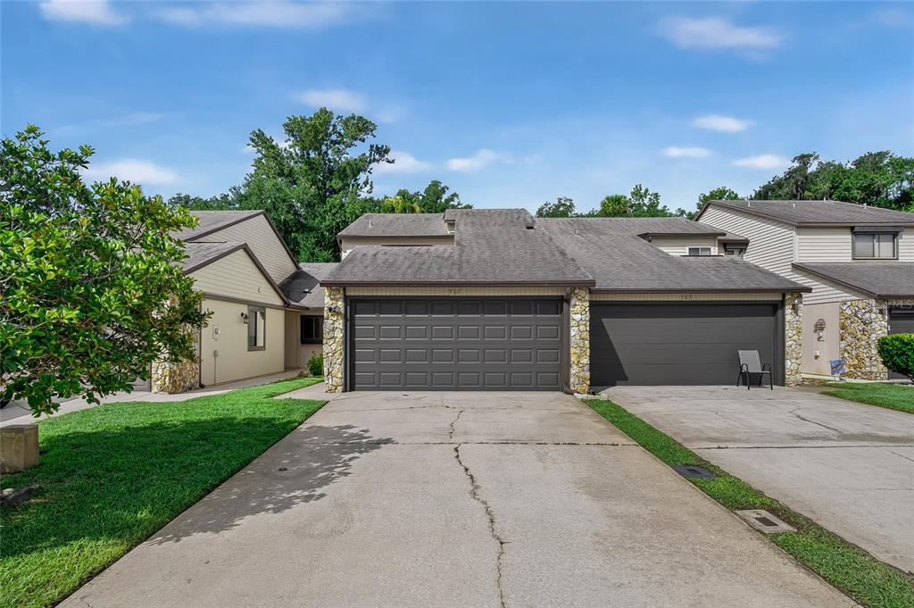 A two-car garage with a concrete driveway in front of a suburban residential house — 367 CASTLEWOOD LANE, NEW SMYRNA BEACH, FL