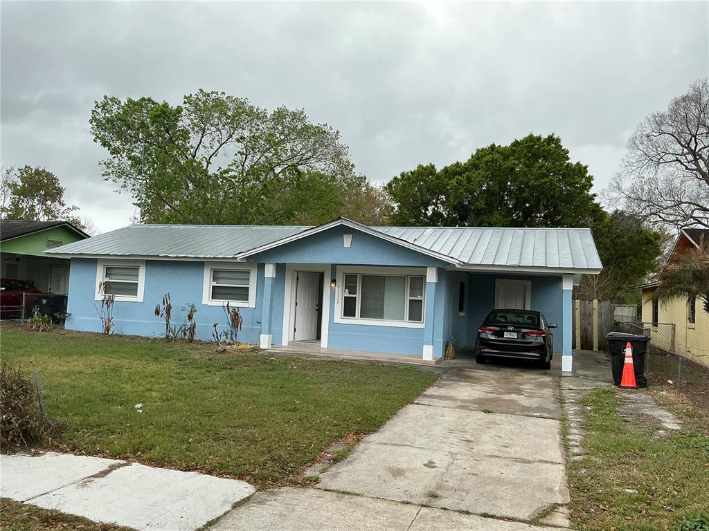 A single-story blue house with a metal roof and a concrete driveway — 5132 ELESE STREET, ORLANDO, FL
