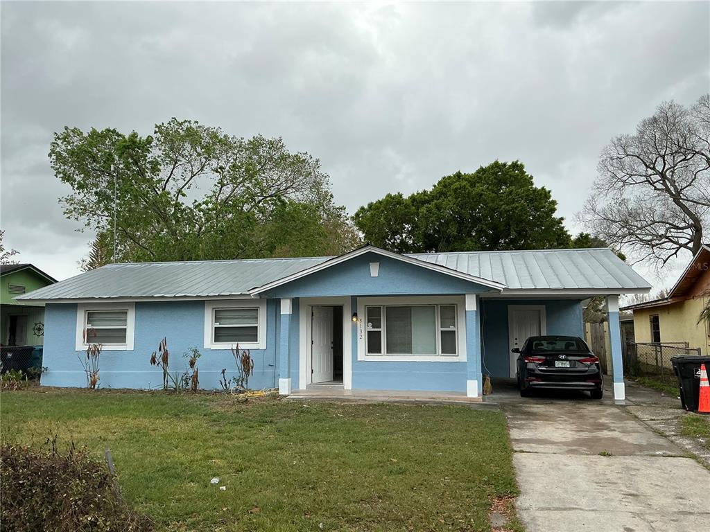 A light blue single-story house with a metal roof and an attached carport — 5132 ELESE STREET, ORLANDO, FL