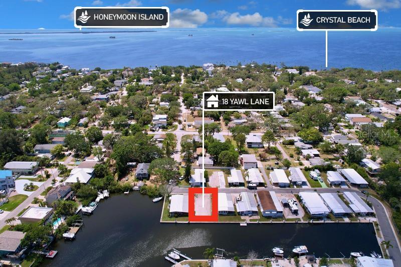 This aerial map shows a vacant waterfront lot highlighted in red within a residential neighborhood — 18 YAWL LANE UNIT 18, PALM HARBOR, FL