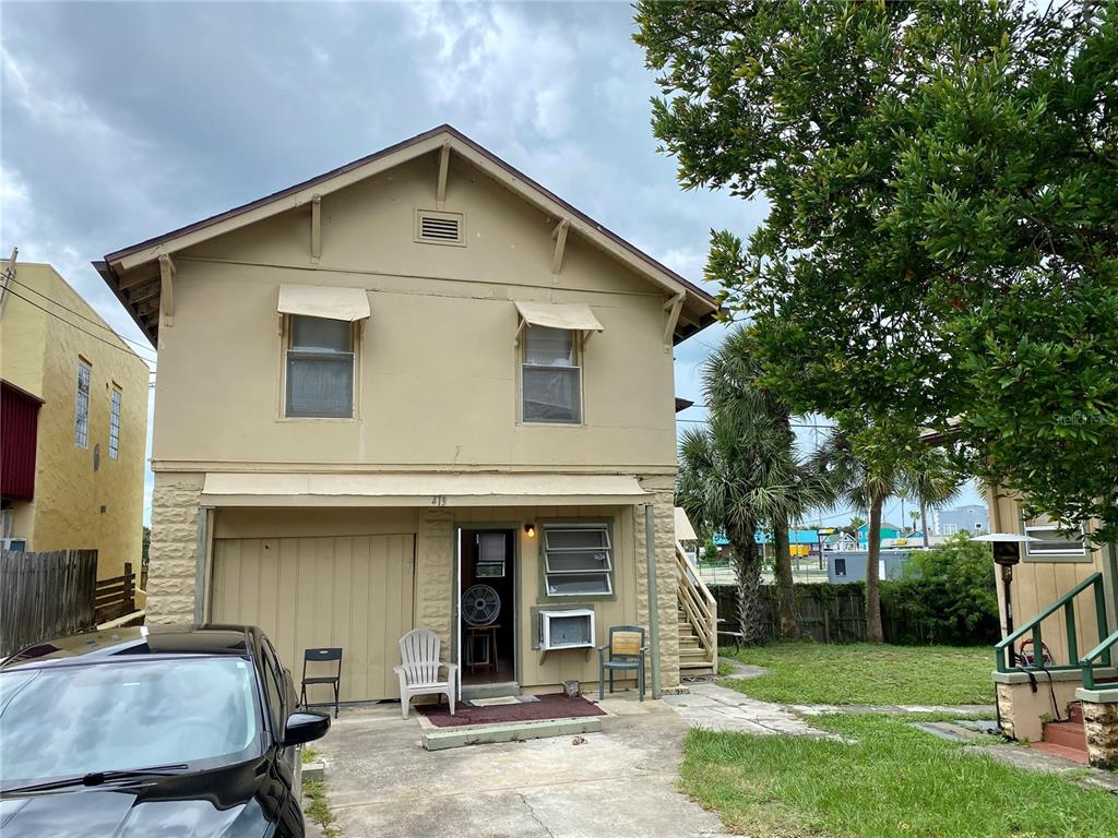 A two-story tan house with a garage, a front door, and a concrete driveway — 415 VERMONT AVENUE, DAYTONA BEACH, FL