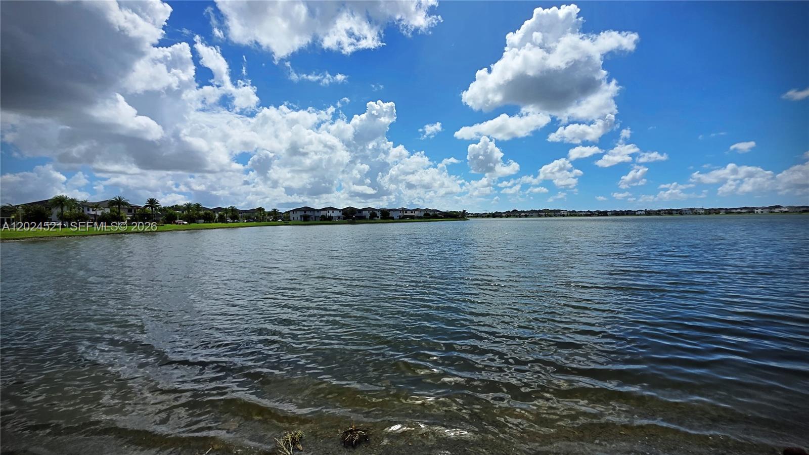 A wide view of a lake with residential houses along the distant shoreline — 16017 NW 91st Ct, Miami Lakes FL 33018, MIAMI LAKES, FL
