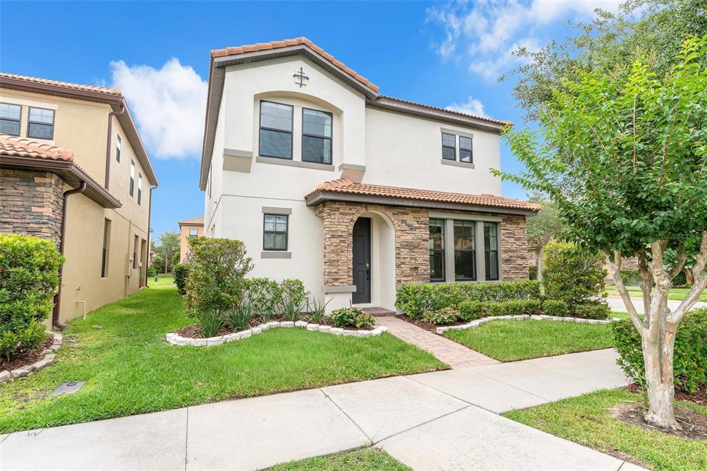 A two-story house with a stucco and stone facade, a tiled roof, and a front walkway — 325 PARTRIDGE PEA LANE, OCOEE, FL