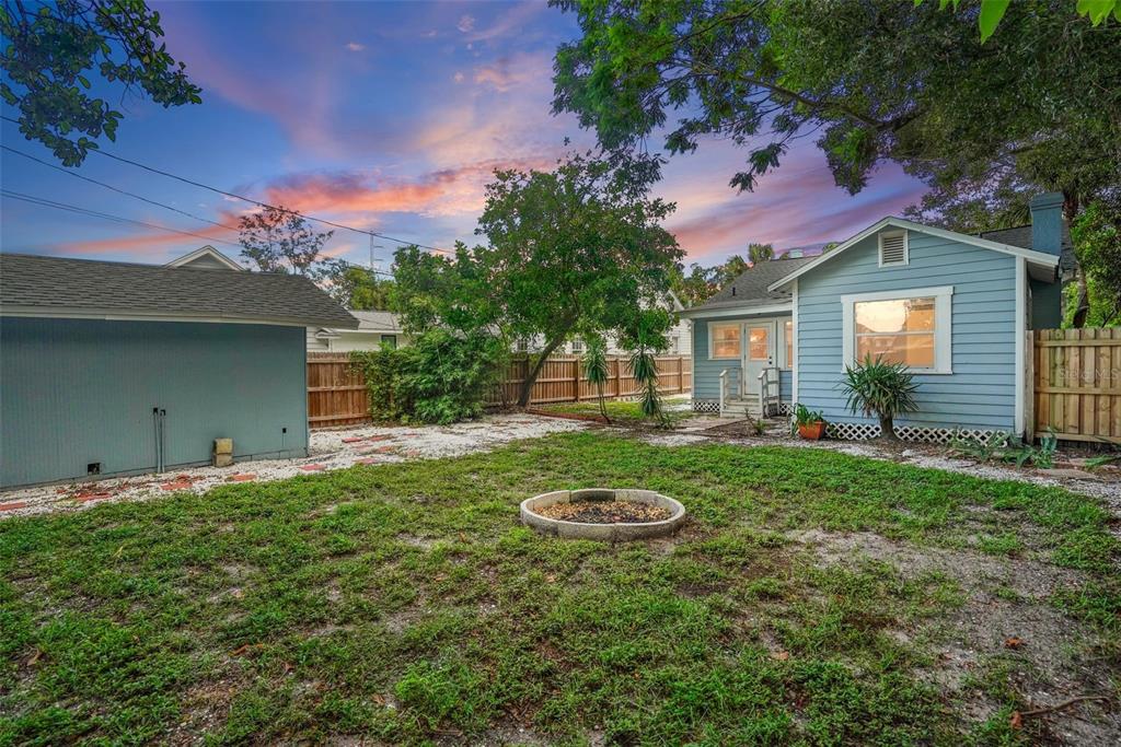 A backyard features a fire pit, a light blue house, and a detached garage — 2111 BURLINGTON AVENUE N, ST PETERSBURG, FL