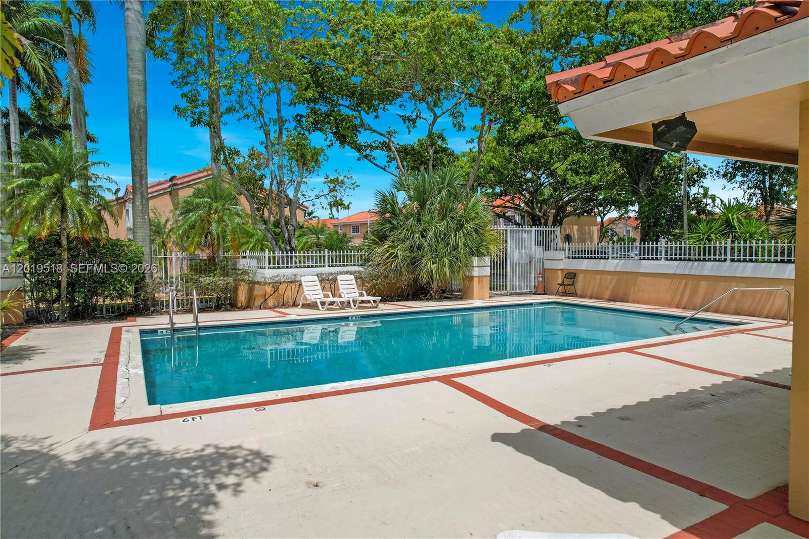 A rectangular swimming pool is surrounded by a concrete deck and white metal fencing — 14245 SW 57th Ln # 5, Miami FL 33183, MIAMI, FL