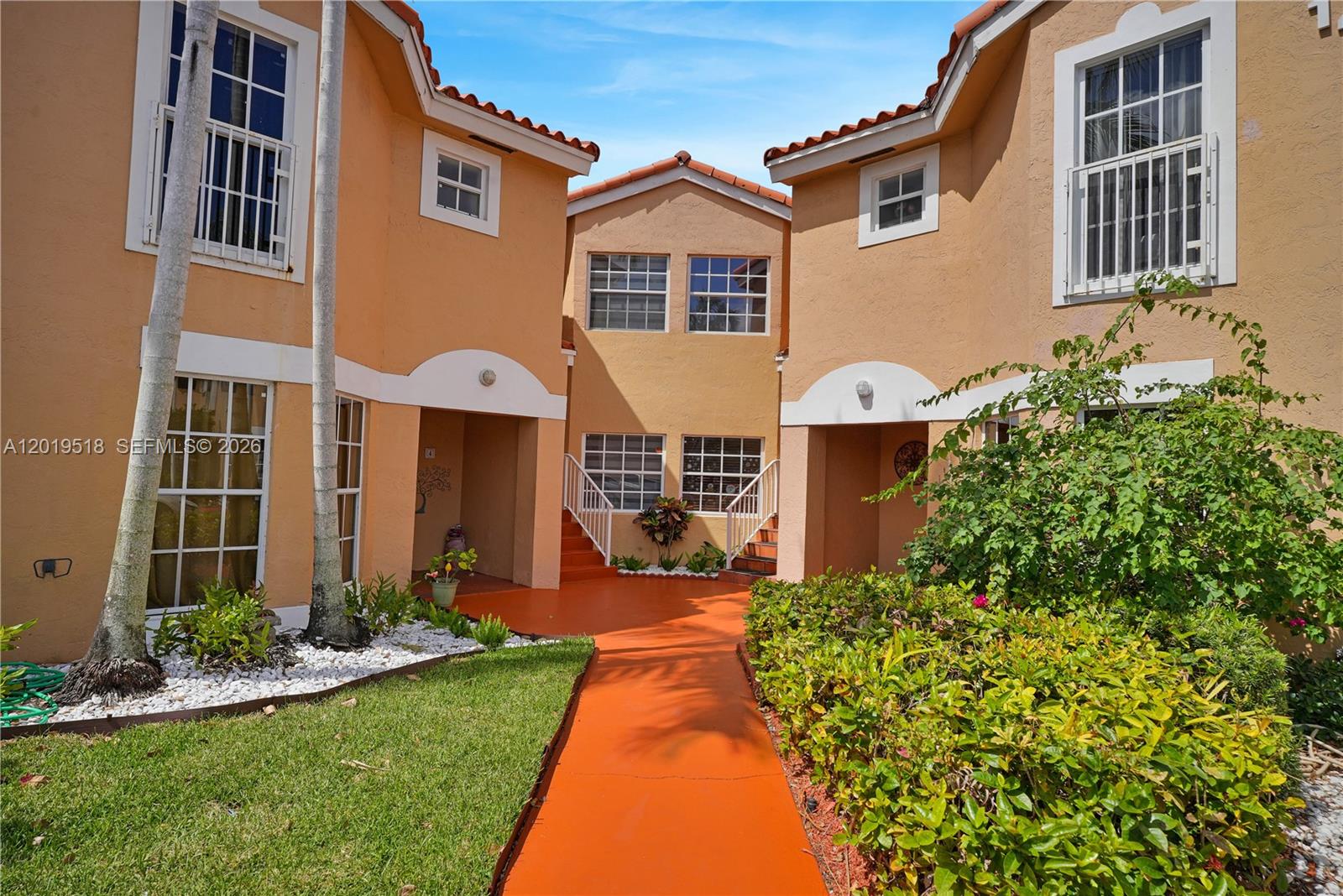 An orange stucco building features a central walkway leading to two separate staircases — 14245 SW 57th Ln # 5, Miami FL 33183, MIAMI, FL