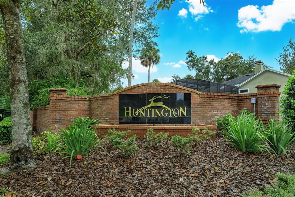 A brick entrance sign for a community named Huntington sits in a landscaped garden — 2381 CHANTILLY TERRACE, OVIEDO, FL