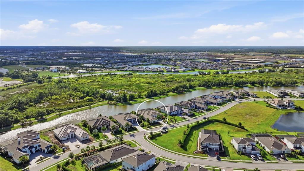 An aerial view shows a residential neighborhood with a circled house near a pond — 4202 BUTTE TRAIL, BRADENTON, FL