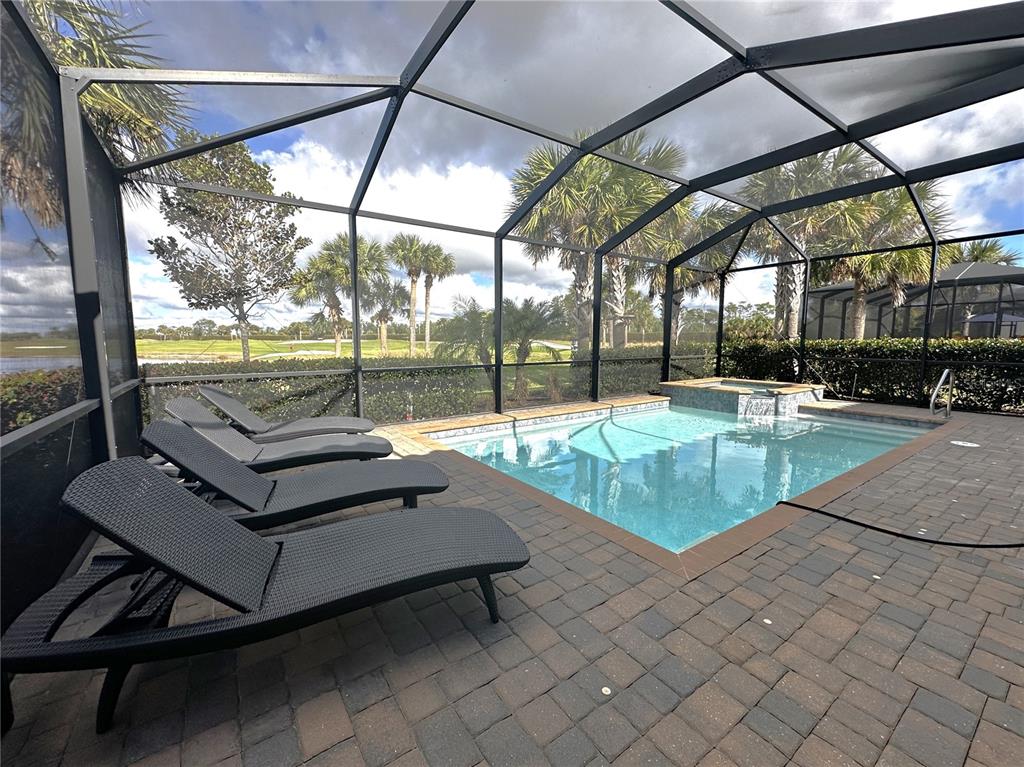 A screened-in patio features a swimming pool, a hot tub, and several lounge chairs — 25222 KEYGRASS COURT, PUNTA GORDA, FL