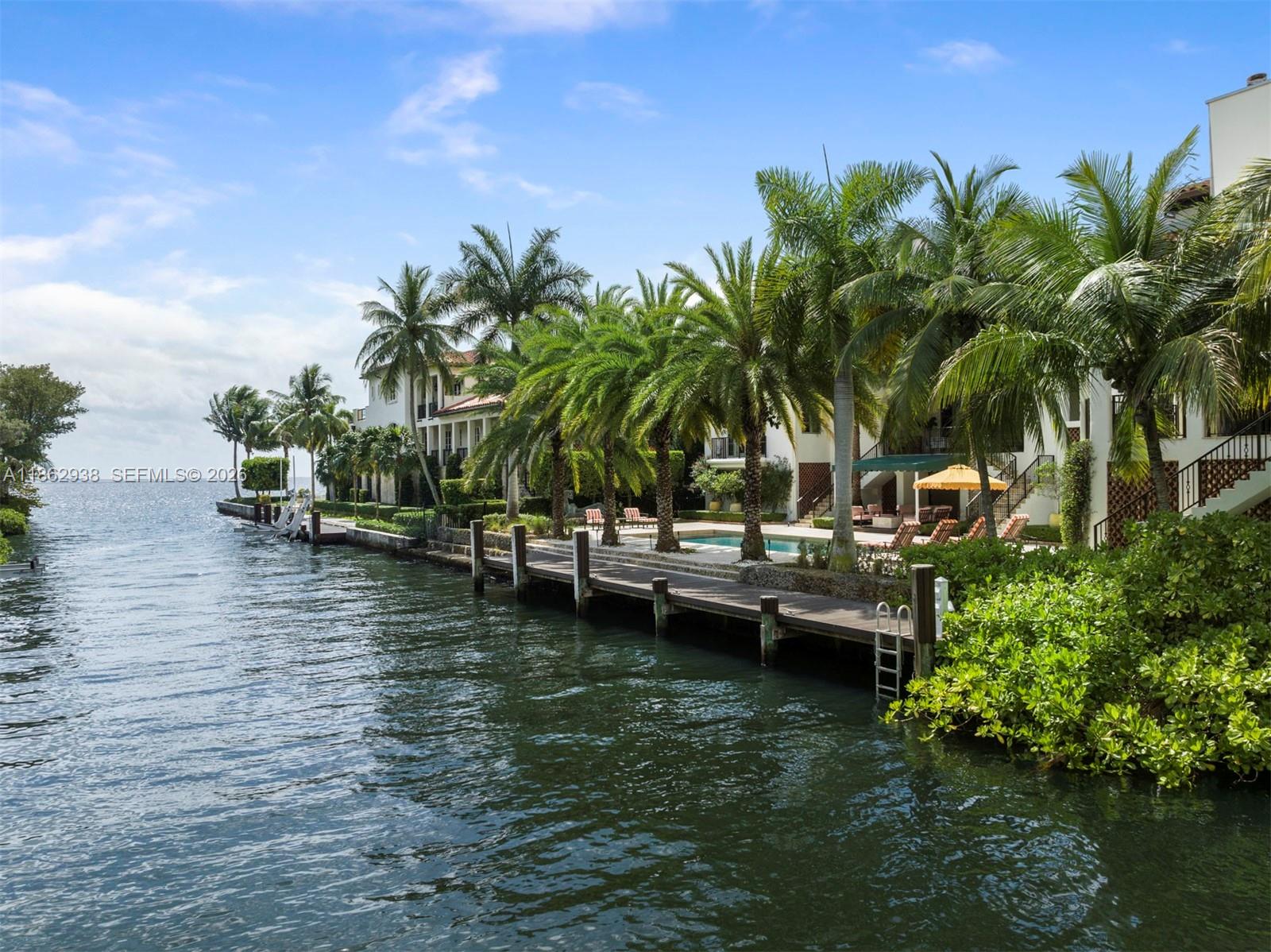 A waterfront property features a wooden dock, a swimming pool, and palm trees — 3305 S Moorings Way, Miami FL 33133, MIAMI, FL