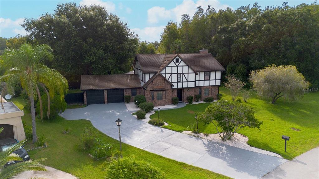 An aerial view of a two-story Tudor-style house with a brick facade and attached garage — 2540 ALBANY DRIVE, KISSIMMEE, FL