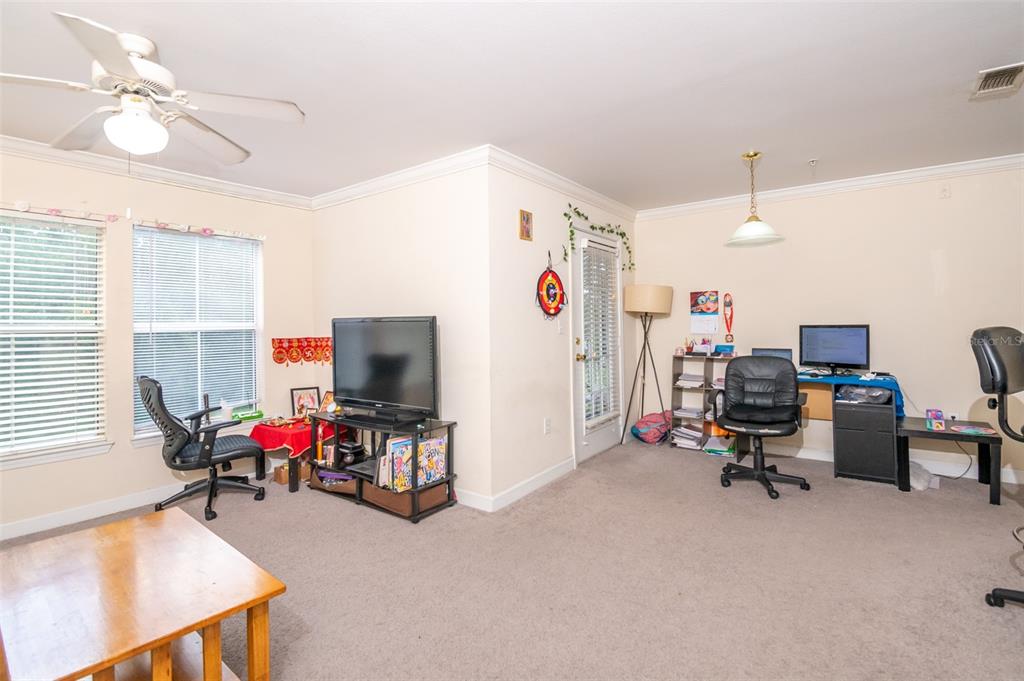 A carpeted room features a ceiling fan, a television on a stand, and office workstations — 18113 BRIDLE CLUB DRIVE, TAMPA, FL
