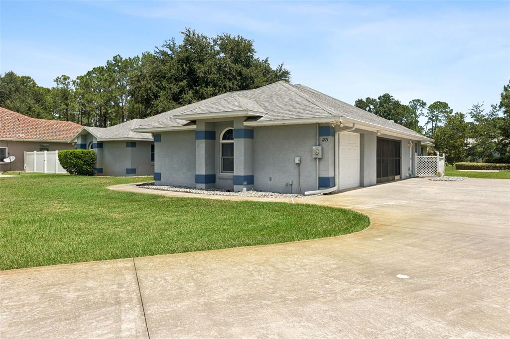 A gray single-story house with a concrete driveway and a white garage door — 23 WELLSTREAM LANE, PALM COAST, FL