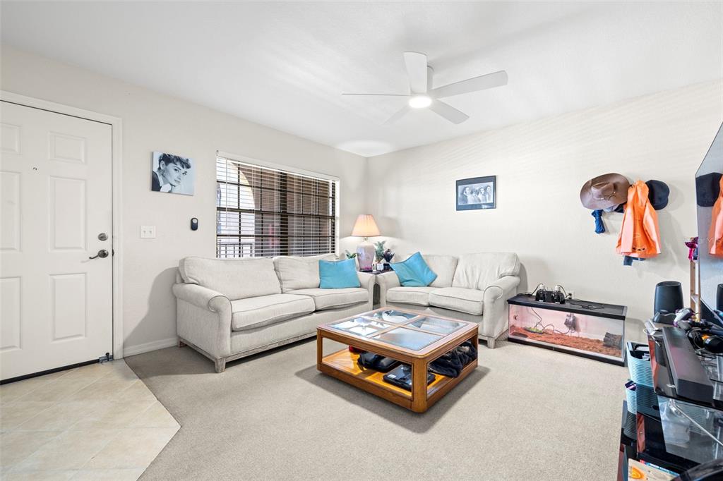 A living room features two light-colored sofas, a wooden coffee table, and a ceiling fan — 6100 GULFPORT BOULEVARD S UNIT 414, GULFPORT, FL