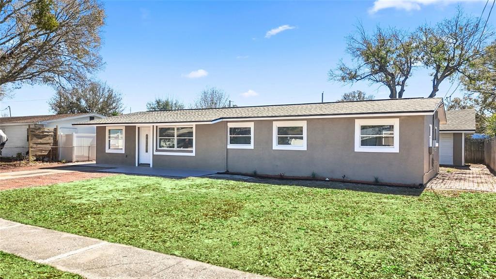 A single-story house with a gray exterior, white trim, and a front lawn — 4418 W FAIRVIEW HEIGHTS, TAMPA, FL