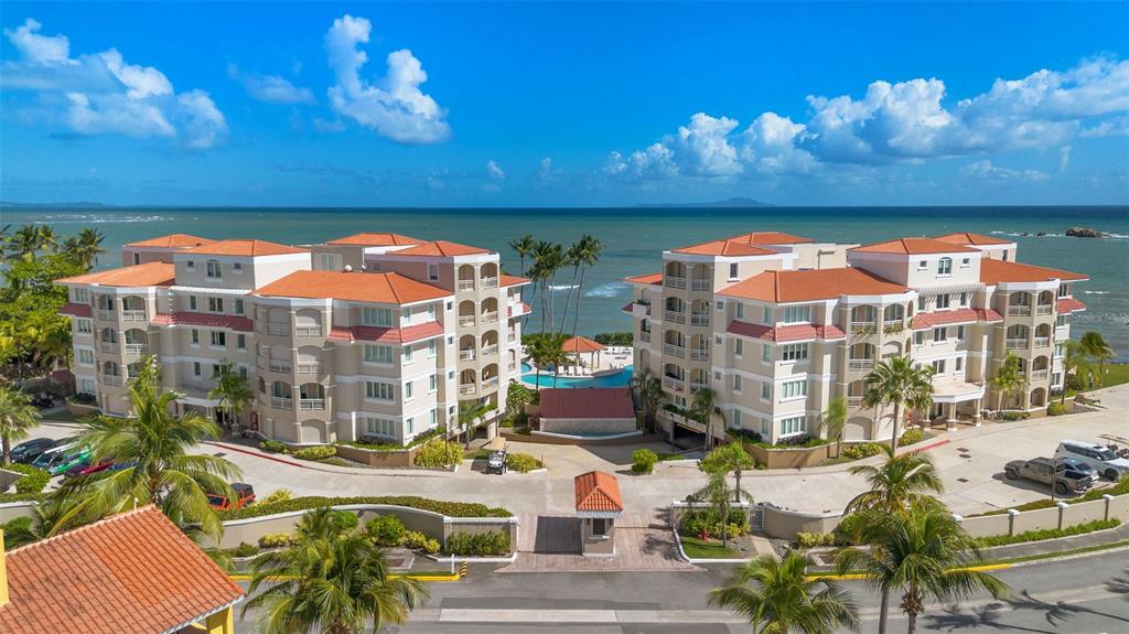 An aerial view of a multi-story apartment complex with a pool overlooking the ocean — 355 HARBOUR DRIVE UNIT 2C South, HUMACAO, PR