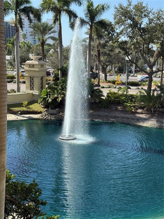 A tall fountain sprays water into a blue pond surrounded by palm trees and landscaping — 800 N TAMIAMI TRAIL UNIT 211, SARASOTA, FL