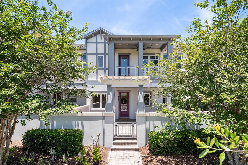A two-story townhouse exterior features a gated courtyard, a pergola, and a second-floor balcony — 9037 LAUREATE BOULEVARD, ORLANDO, FL