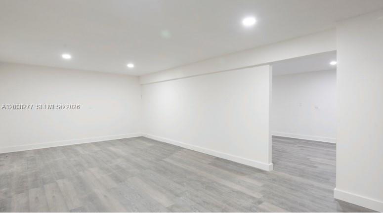 An empty room with white walls, recessed lighting, and gray wood-look flooring — 405 N Charles St, Daytona FL 32114, DAYTONA, FL