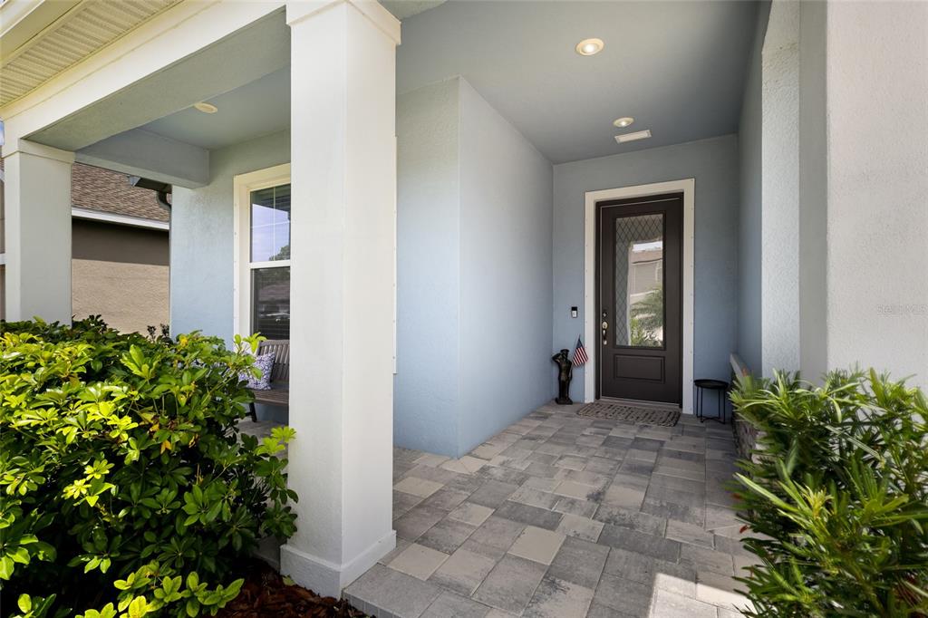 A covered front porch features light blue walls, white columns, and a dark front door — 8611 MERCATOR COURT, PARRISH, FL