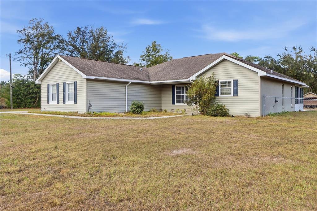 A single-story house with light green siding and a brown shingled roof — 11631 SE 195TH PLACE, DUNNELLON, FL