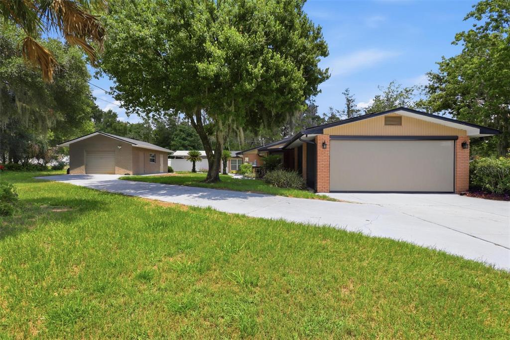 A house with a large garage and a separate detached garage on a grassy lot — 1570 GLENWOOD ROAD, DELAND, FL