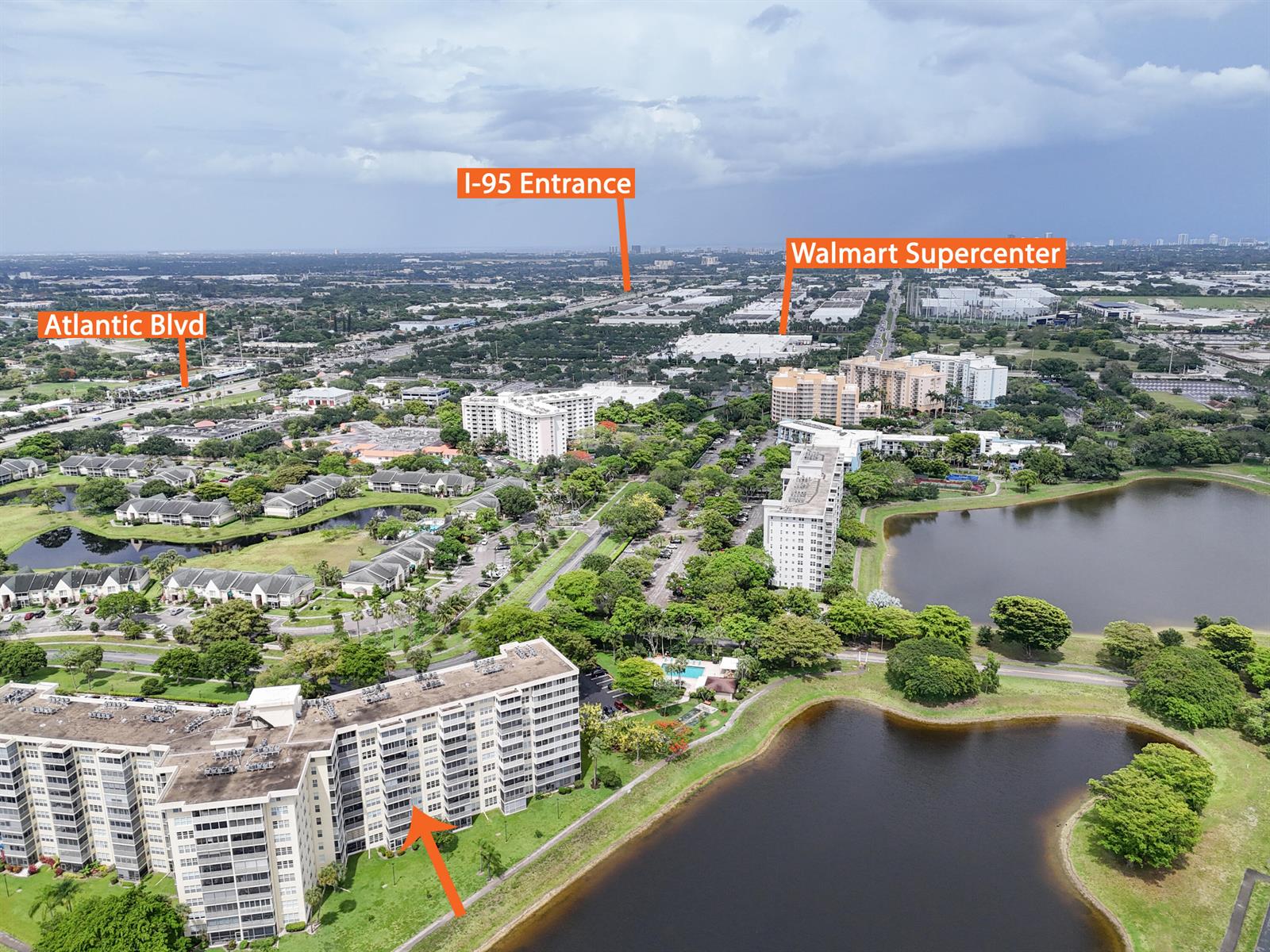 An aerial view shows a residential complex with multiple buildings, a lake, and surrounding roads — 3095 N Course Drive # 409, Pompano Beach FL 33069, POMPANO BEACH, FL