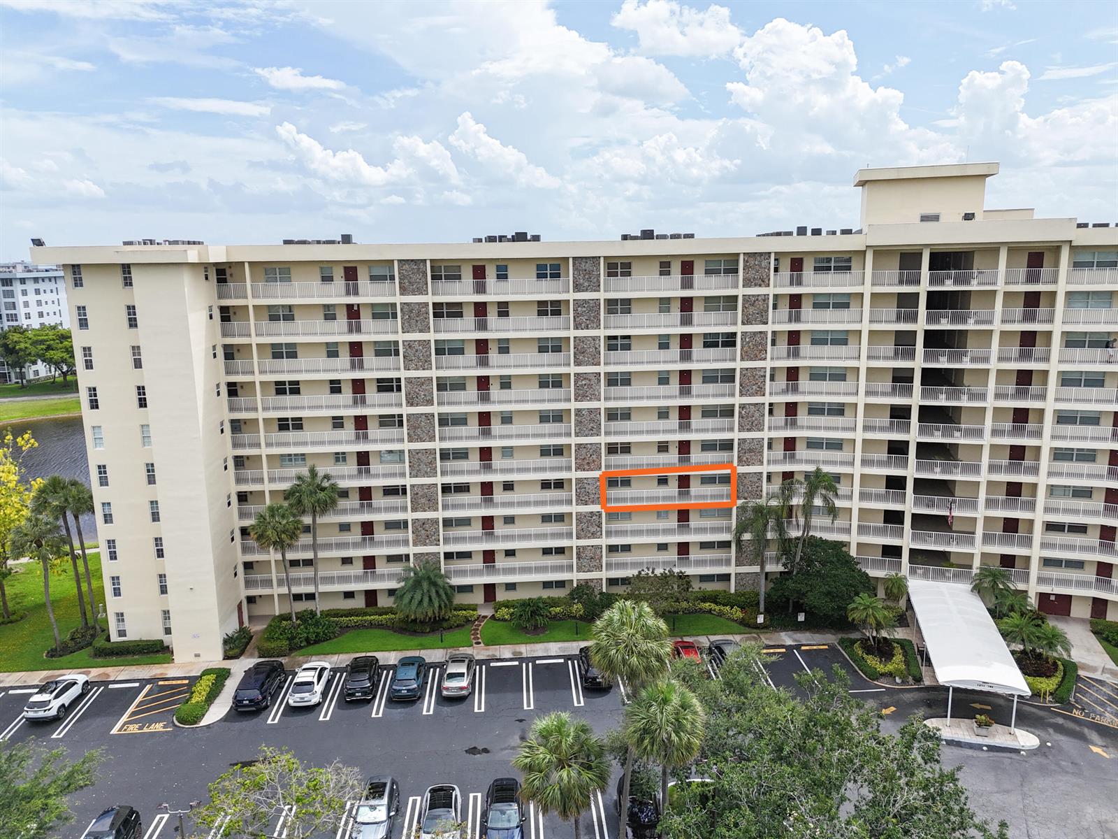 An exterior view of a multi-story apartment building with a highlighted balcony — 3095 N Course Drive # 409, Pompano Beach FL 33069, POMPANO BEACH, FL