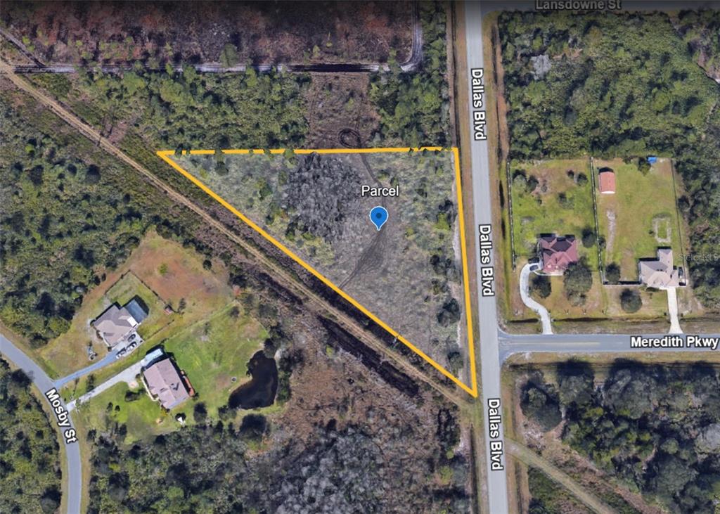 An aerial map view shows a triangular vacant parcel of land bordered by roads — DALLAS BOULEVARD, ORLANDO, FL